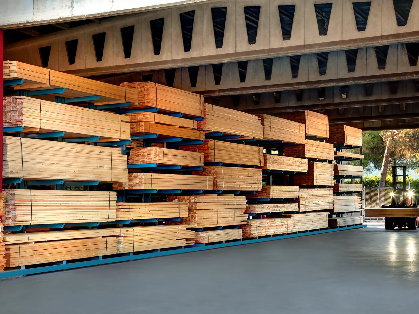Bodega MATRI con tarimas de tableros de madera estibados y montacargas