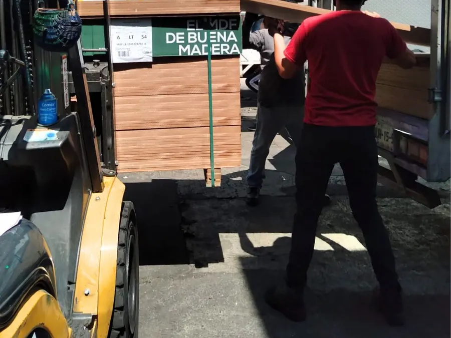 Cliente cargando tableros en su camioneta en sucursal